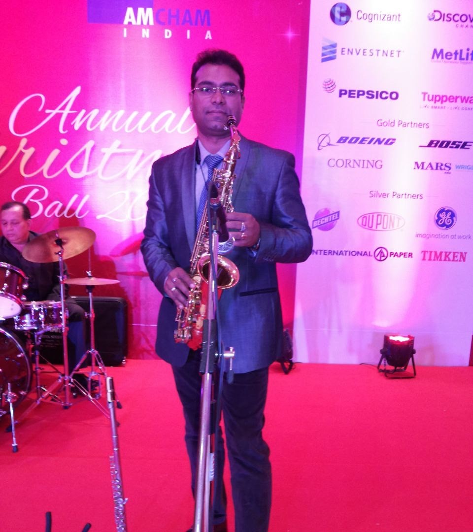 Vikas Gautam playing tenor saxophone at an outdoor evening show